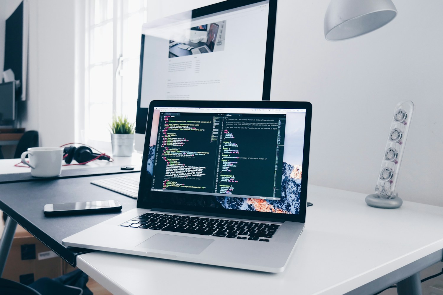 Laptop and monitor in a software development workspace